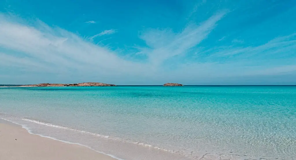 the untouched natural beauty of Ses Illetes, where the sparkling waters stretch out as far as the eye can see against a backdrop of rolling dunes and greenery.